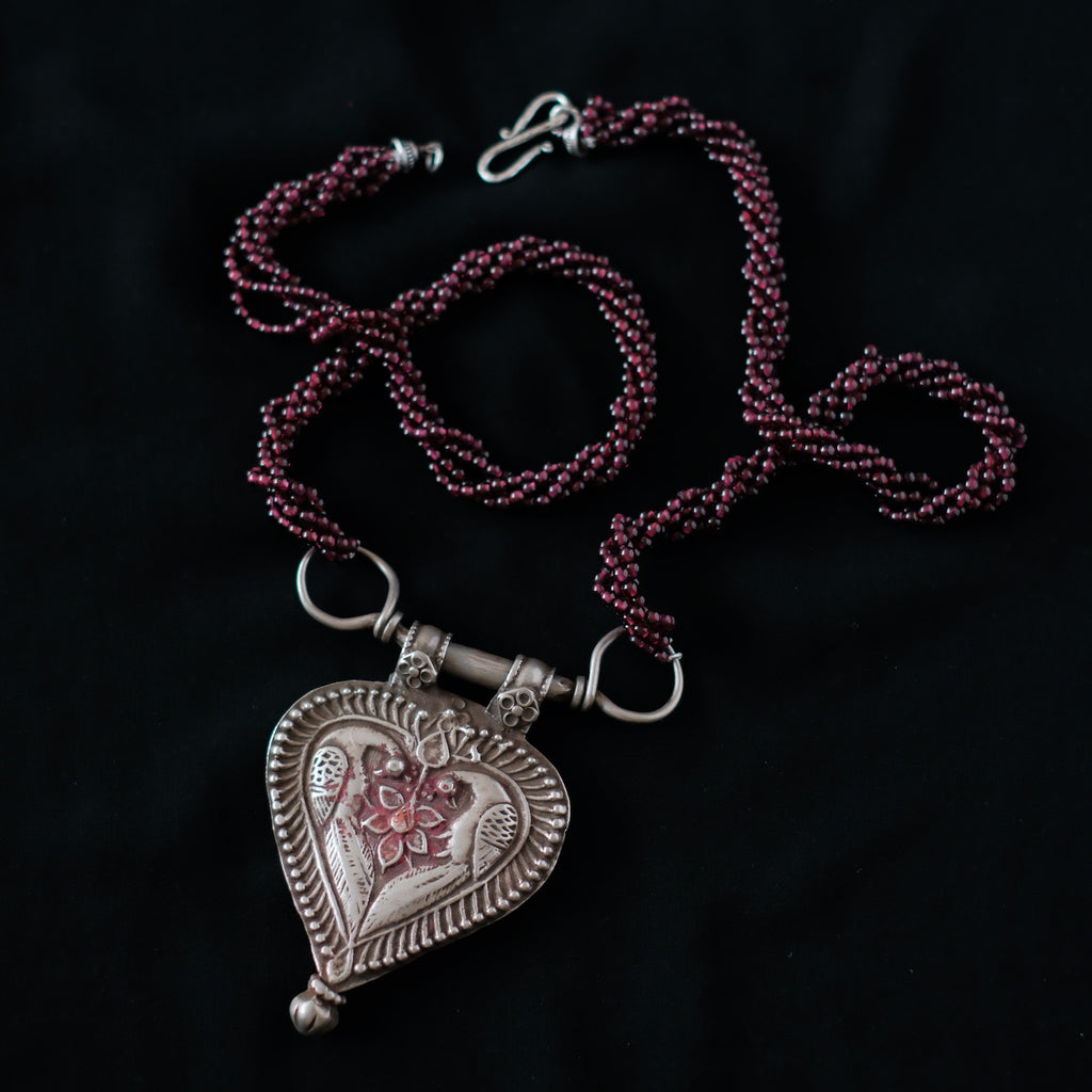 Collar diseñado por Lula Máiz con antiguo colgante de India, de plata representando dos pavos reales , ave que en la mitología hindú esta asociada con Lakshmi , la diosa de la prosperidad, belleza y compasión. Esta engarzado en esta pieza única con varias vueltas de granates. El cierre es contemporaneo, de plata. Longitud 73 cm Medidas colgante 8 cm x 6 cm Peso 140 gr.One of a kind by Lula Maiz