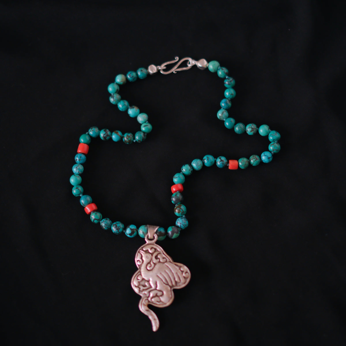Collar con turquesas, coral y colgante tibetano hecho a mano con plata, coral y turquesas, representando una serpiente, animal que simboliza la renovacion, transformacion y sabiduria. La parte posterior tiene un exquisito trabajo artesanal, y puede ser usado por ambos lados. El cierre es de plata de ley. Longitud 51 cm Peso 56 g One of a kind by Lula Máiz