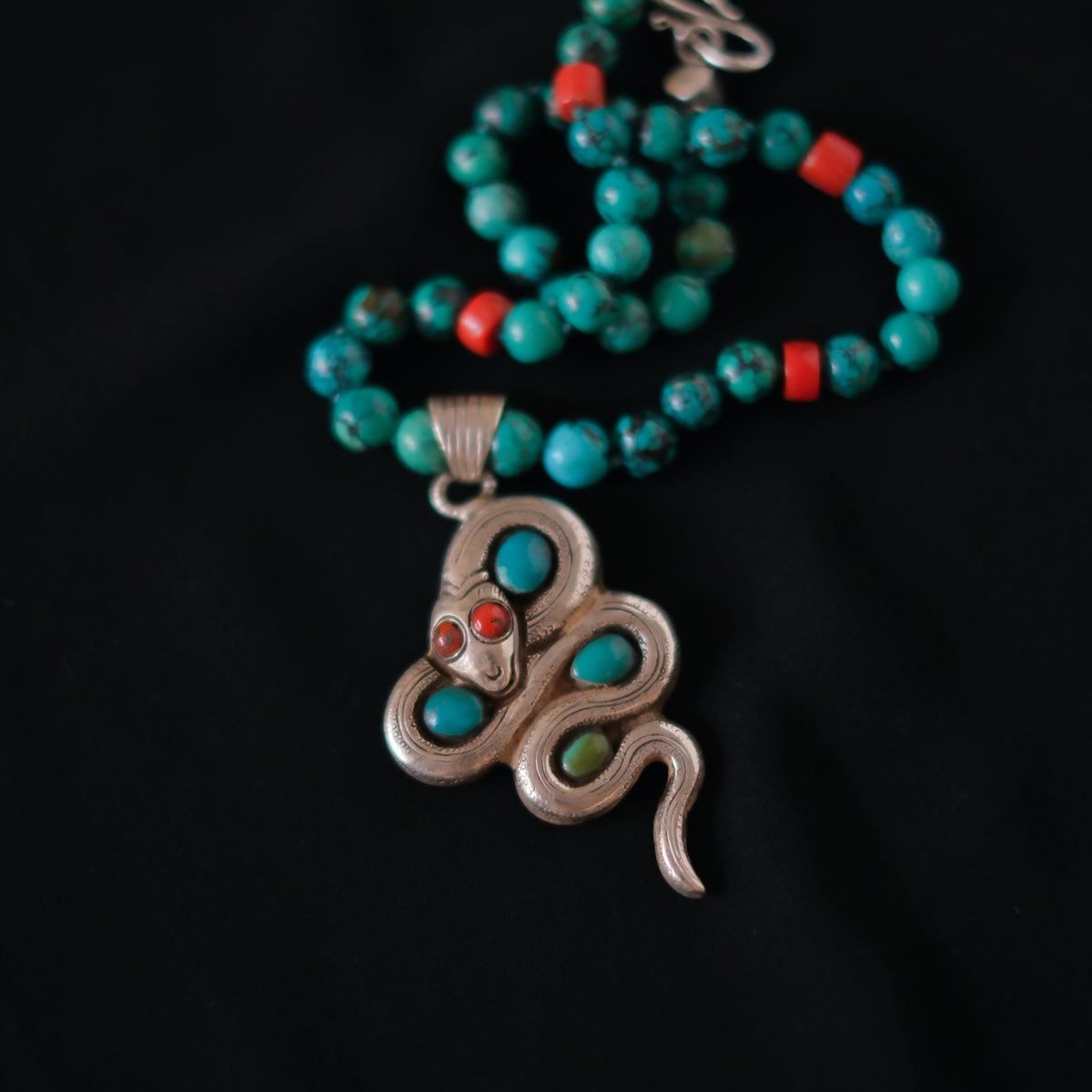 Collar con turquesas, coral y colgante tibetano hecho a mano con plata, coral y turquesas, representando una serpiente, animal que simboliza la renovacion, transformacion y sabiduria. La parte posterior tiene un exquisito trabajo artesanal, y puede ser usado por ambos lados. El cierre es de plata de ley. Longitud 51 cm Peso 56 g One of a kind by Lula Máiz