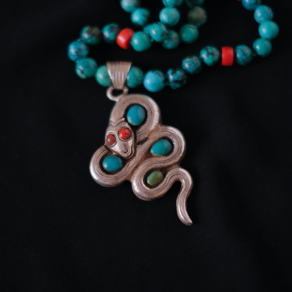 Collar con turquesas, coral y colgante tibetano hecho a mano con plata, coral y turquesas, representando una serpiente, animal que simboliza la renovacion, transformacion y sabiduria. La parte posterior tiene un exquisito trabajo artesanal, y puede ser usado por ambos lados. El cierre es de plata de ley. Longitud 51 cm Peso 56 g One of a kind by Lula Máiz