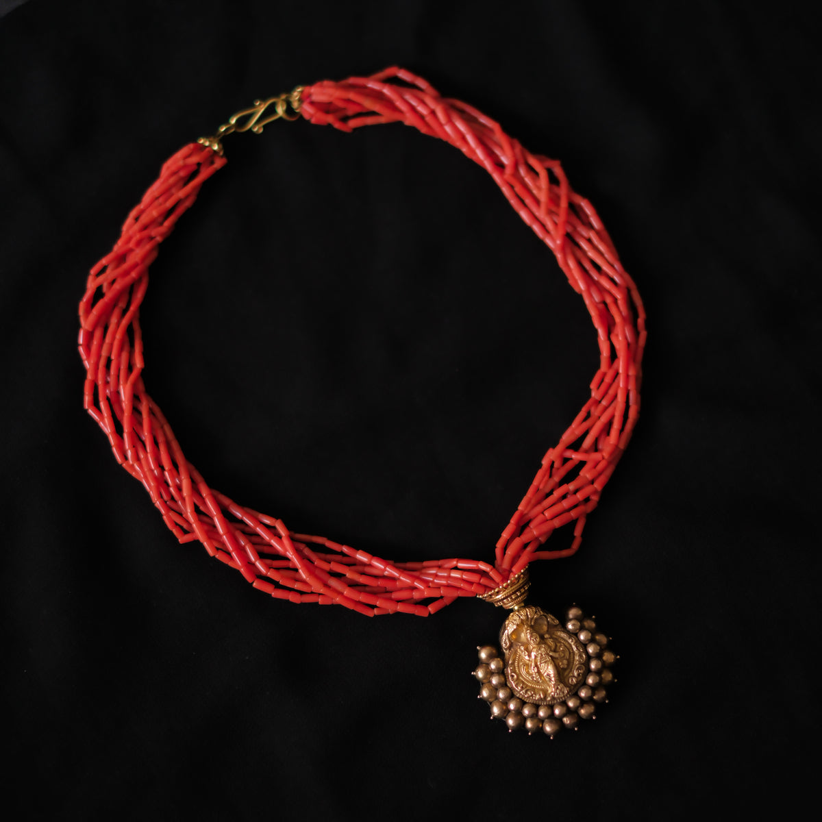 Collar con colgante antiguo de India de oro y metal en la parte posterior representando a Laksmi , diosa de la prosperidad material y espiritual para los hindúes, que simboliza la buena suerte. Esta combinado en esta pieza única de Lula Máiz con 9 vueltas de coral y cuentas de oro. El cierre es también de oro. Longitud 44 cm Medidas colgante 3´5 x 3´5 cm Peso 49 g One of a kind by Lula Máiz