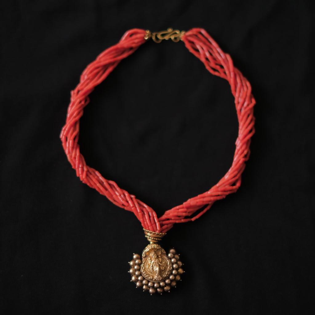 Collar con colgante antiguo de India de oro y metal en la parte posterior representando a Laksmi , diosa de la prosperidad material y espiritual para los hindúes, que simboliza la buena suerte. Esta combinado en esta pieza única de Lula Máiz con 9 vueltas de coral y cuentas de oro. El cierre es también de oro. Longitud 44 cm Medidas colgante 3´5 x 3´5 cm Peso 49 g One of a kind by Lula Máiz