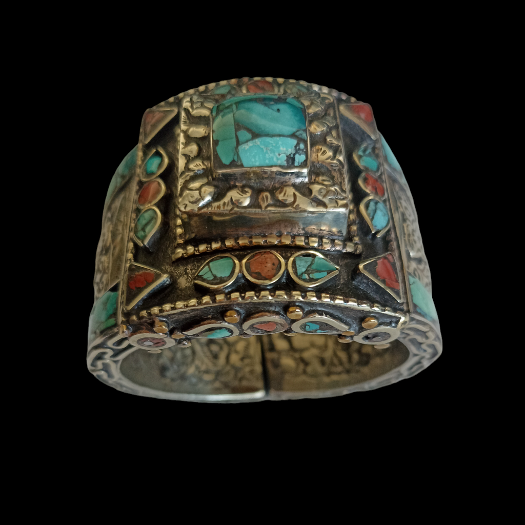 Brazalete artesanal tibetano hecho a mano con aleación de plata y coral y turquesa prensados. Decorada con 2 dragones, El dragón es símbolo de fuerza, coraje y sabiduría en Oriente y portador de buena suerte.   Se abre por la parte posterior mediante bisagras.  Contorno interior 17 cm  Apertura  máxima 2´5 cm Ancho 5 cm Peso  150 g. Hand made tibetan cuff bracelet