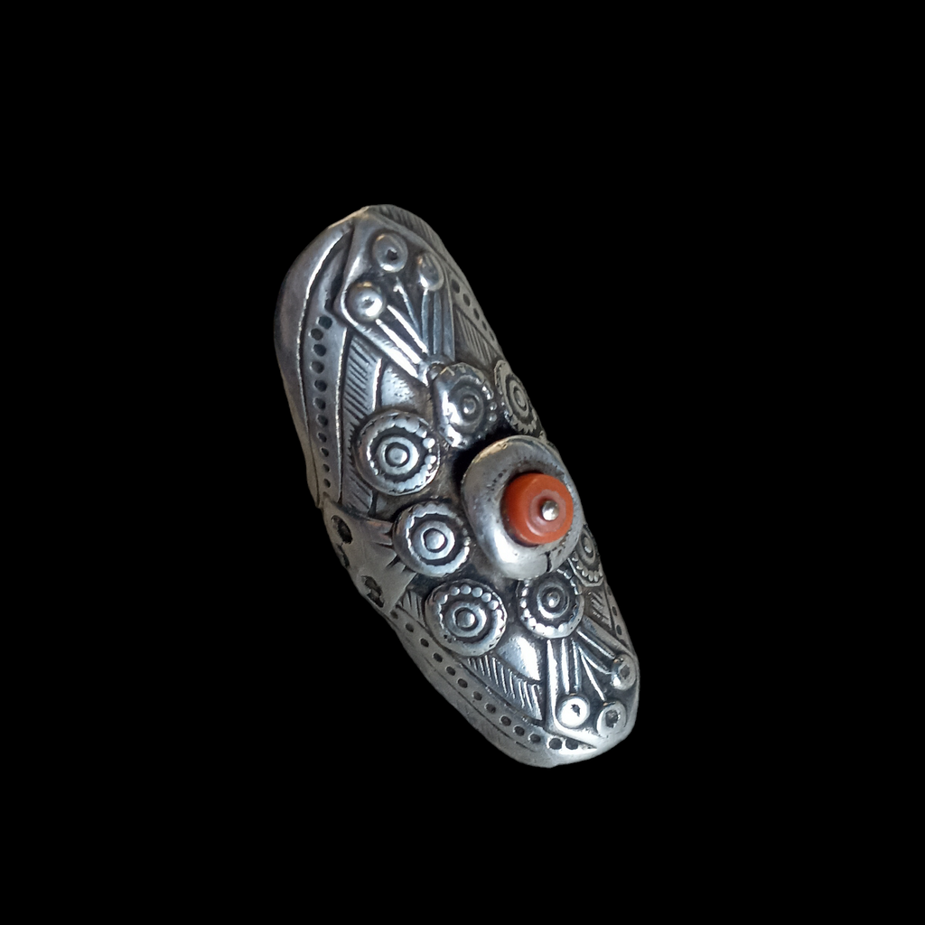 Anillo antiguo hecho a mano con plata y coral, de Yemen. Es una pieza única con un diseño muy particular y una patina extraordinaria. Esta abierto por la parte posterior, seguramente cortado por su propietaria cuando ya no le servía. Longitud 4´5 cm Tamaño 15 ( adaptable) Peso  11 g. Antique silver ring from Yemen. Lula Máiz