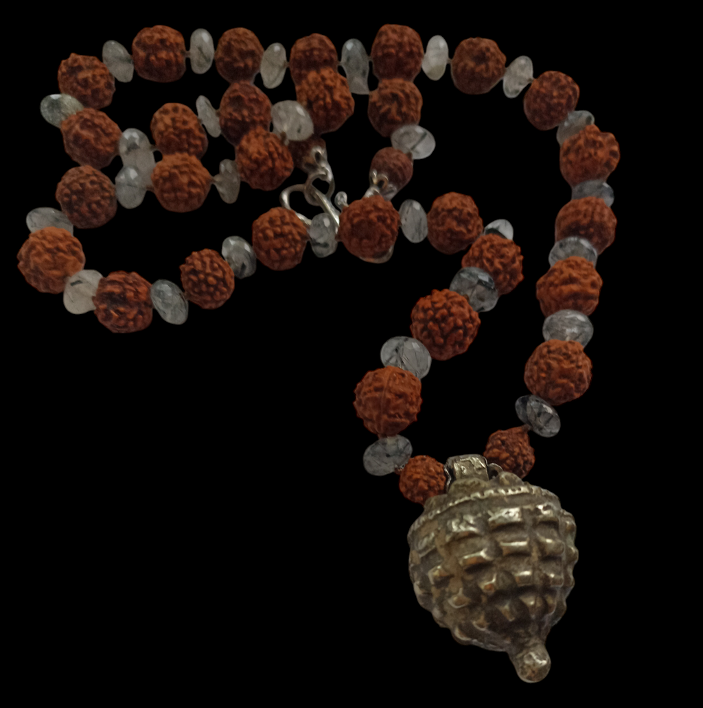 Collar con semillas de rudraksha, estas semillas (también llamadas lagrimas de Shiva ) se usan tradicionalmente para orar en el budismo e hinduismo,asi como en en la medicina tradicional india por sus supuestas propiedades curativas. El colgante antiguo de plata es de India y va engarzado con cuentas de cuarzo rutilado negro. El cierre es contemporáneo, también de plata. Longitud 56 cm Peso 53 g.One of a kind by Lula Máiz.