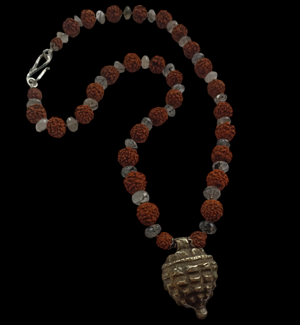 Collar con semillas de rudraksha, estas semillas (también llamadas lagrimas de Shiva ) se usan tradicionalmente para orar en el budismo e hinduismo,asi como en en la medicina tradicional india por sus supuestas propiedades curativas. El colgante antiguo de plata es de India y va engarzado con cuentas de cuarzo rutilado negro. El cierre es contemporáneo, también de plata. Longitud 56 cm Peso 53 g.One of a kind by Lula Máiz.