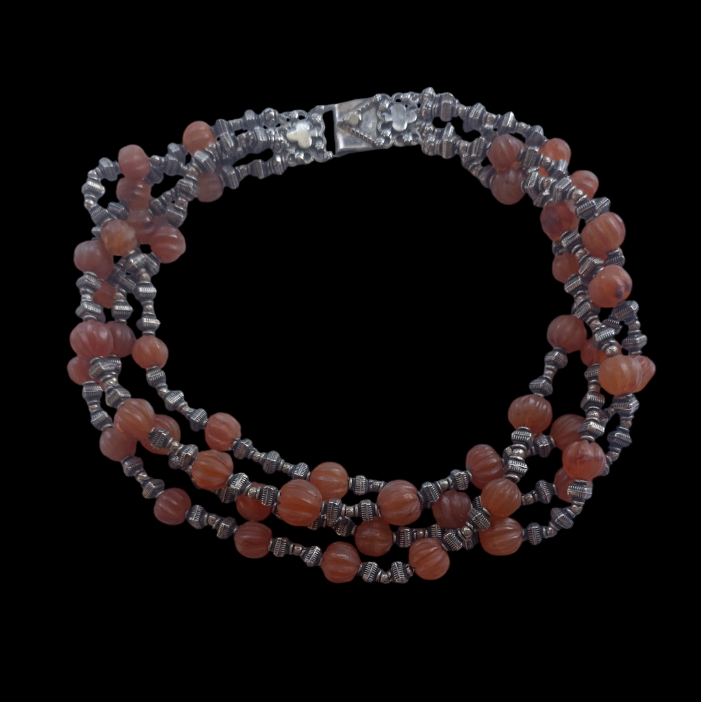 Gargantilla de 4 vueltas con ágatas de forma melón y cuentas de plata de ley. El cierre es también de plata. Longitud 44 cm Peso 180 g. Necklace with 4 strands of melon agate beads  and silver.