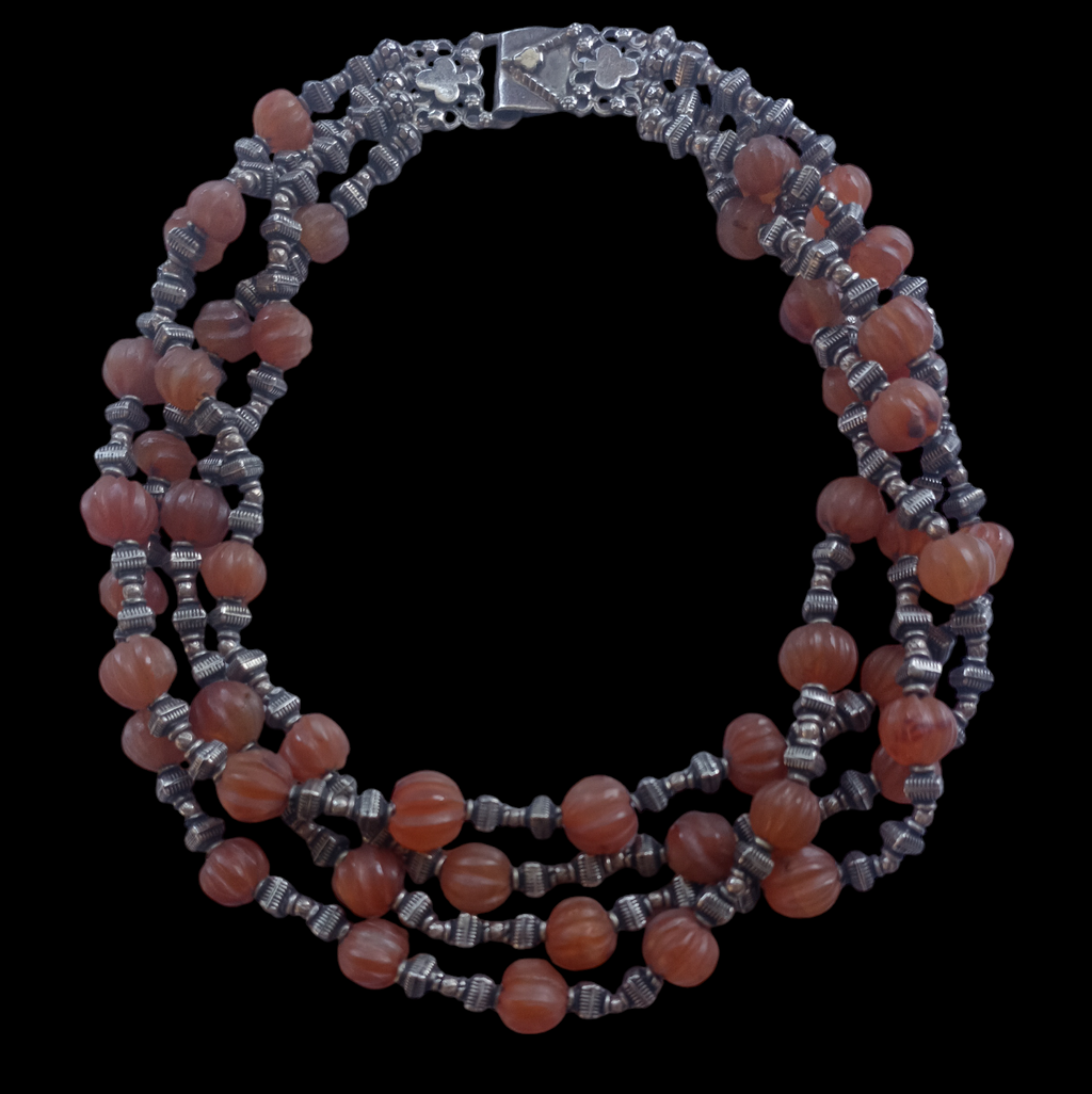 Gargantilla de 4 vueltas con ágatas de forma melón y cuentas de plata de ley. El cierre es también de plata. Longitud 44 cm Peso 180 g. Necklace with 4 strands of melon agate beads  and silver.