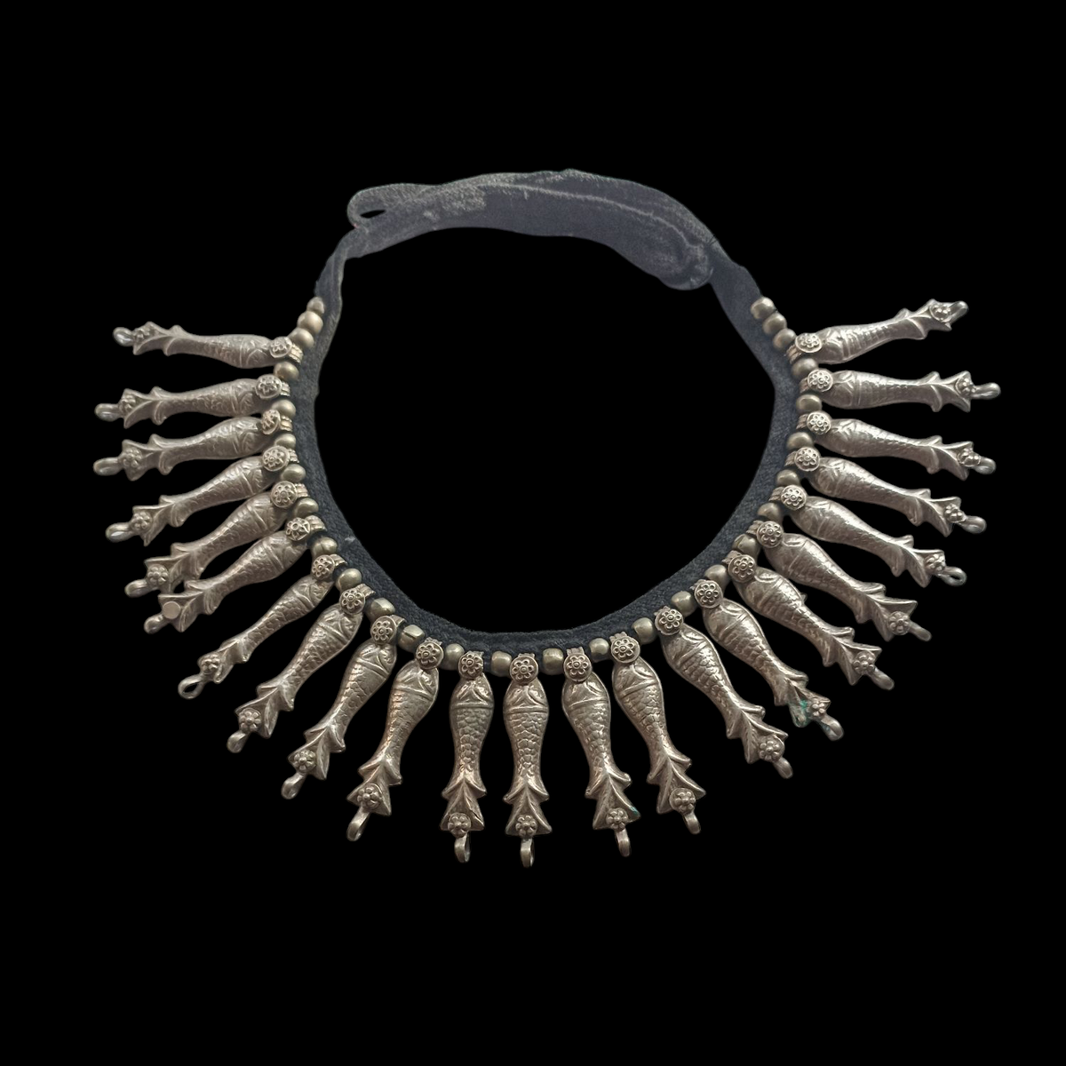 Collar antiguo del pueblo nómada Kuchi, que viven en Afganistán. Esta hecho a mano con plata y conserva el algodón original y el botón de cierre. Los peces son muy venerados en muchas culturas tribales porque se asocian con el agua, fuente de vida. Longitud 50 cm Longitud peces 5 cm Peso 115 g Old Kuchi necklace. Lula Máiz