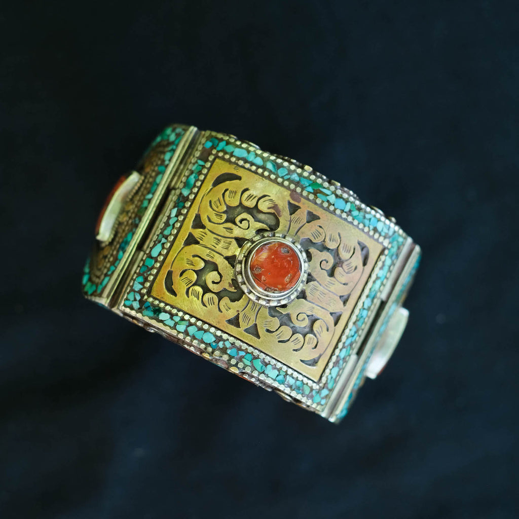 Pulsera tibetana hecha a mano en aleación de plata con turquesa y coral. Se abre y cierra fácilmente con una pestaña oculta. El interior esta decorado también con filigrana realizada en laton. Medida interior 18 cm. Peso 122 g. Joyas artesanales. Piezas únicas. Pulsera artesanal.